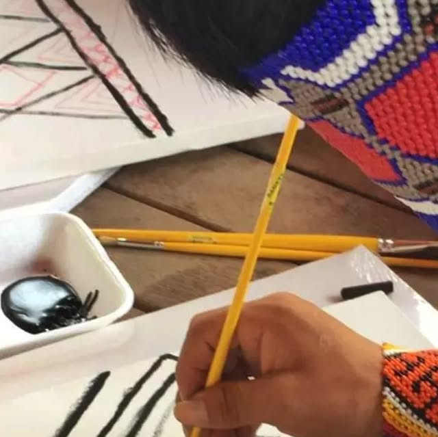 Oficina de arte com nativos no Acre: mão pintando com pincel