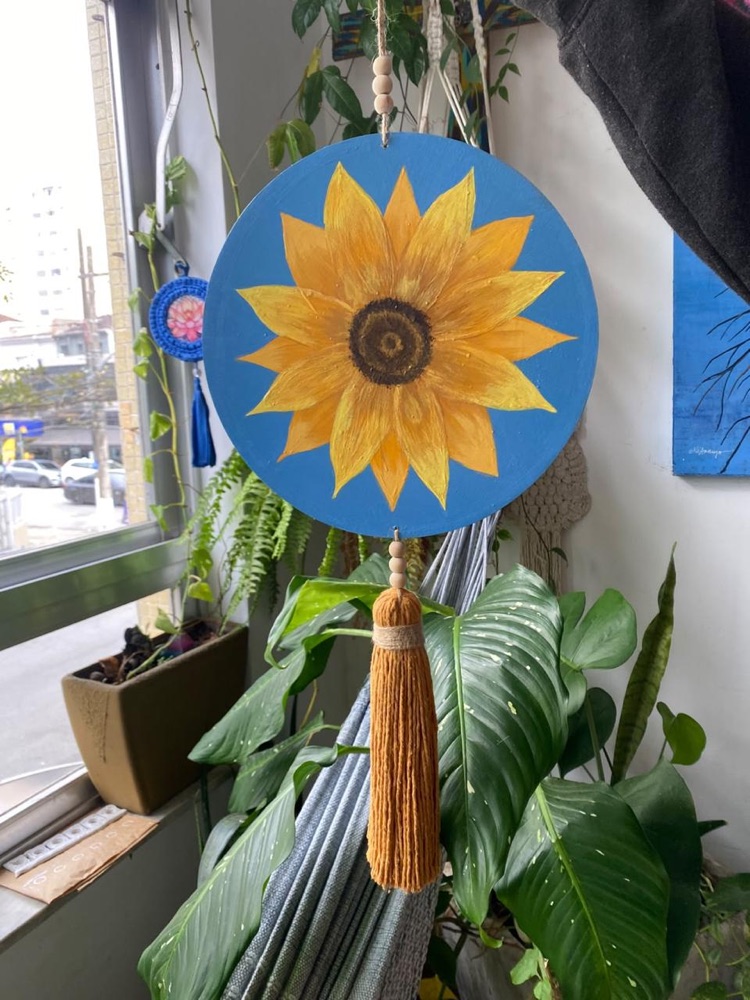 Girassol pintado à mão em disco azul, com borla, pendurado como objeto decorativo